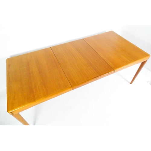 1757 - Vintage / Retro: A mid century extending teak dining table raised on four turned tapering legs and h... 