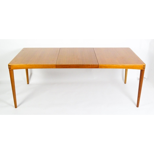 1757 - Vintage / Retro: A mid century extending teak dining table raised on four turned tapering legs and h... 