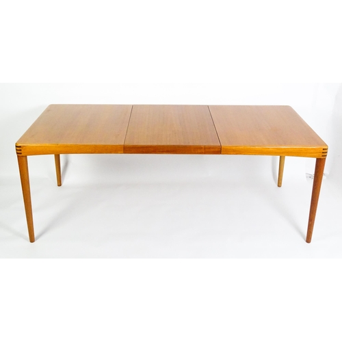 1757 - Vintage / Retro: A mid century extending teak dining table raised on four turned tapering legs and h... 