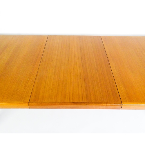 1757 - Vintage / Retro: A mid century extending teak dining table raised on four turned tapering legs and h... 