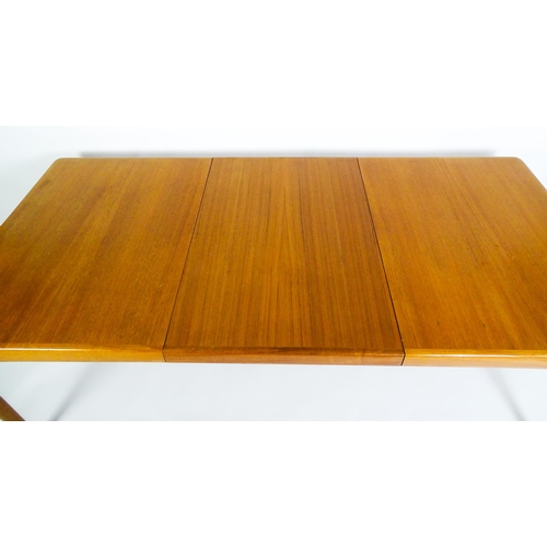 1757 - Vintage / Retro: A mid century extending teak dining table raised on four turned tapering legs and h... 