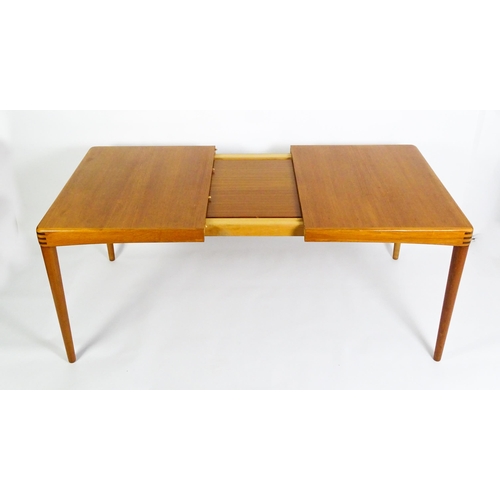 1757 - Vintage / Retro: A mid century extending teak dining table raised on four turned tapering legs and h... 