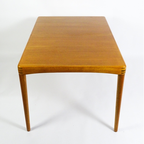 1757 - Vintage / Retro: A mid century extending teak dining table raised on four turned tapering legs and h... 