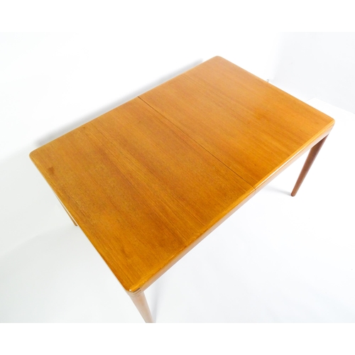 1757 - Vintage / Retro: A mid century extending teak dining table raised on four turned tapering legs and h... 