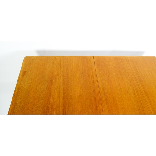 1757 - Vintage / Retro: A mid century extending teak dining table raised on four turned tapering legs and h... 