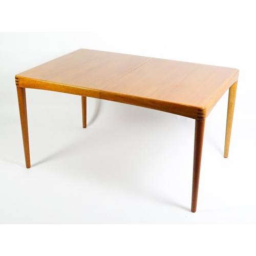 1757 - Vintage / Retro: A mid century extending teak dining table raised on four turned tapering legs and h... 