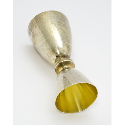 269 - A silver double ended spirit measure / jigger with gilded interiors. Hallmarked Birmingham 1965, mak... 