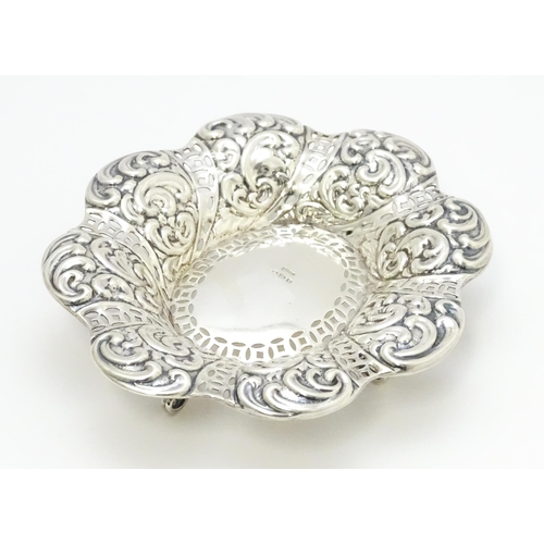 329 - A Victorian silver bon bon dish with pierced and embossed decoration raised on four feet hallmarked ... 