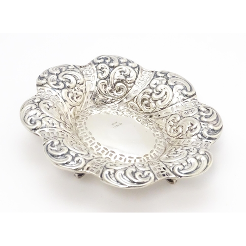 329 - A Victorian silver bon bon dish with pierced and embossed decoration raised on four feet hallmarked ... 