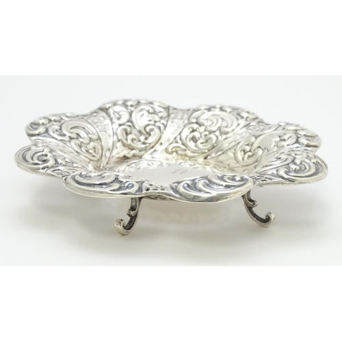 329 - A Victorian silver bon bon dish with pierced and embossed decoration raised on four feet hallmarked ... 