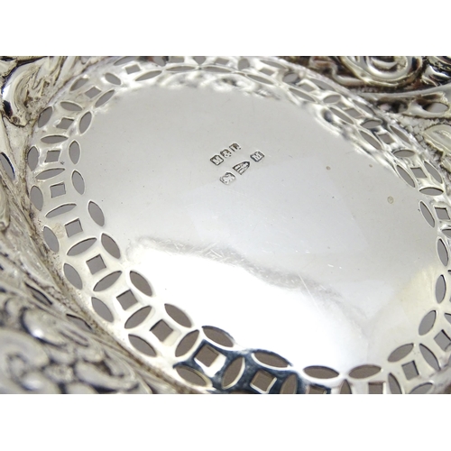 329 - A Victorian silver bon bon dish with pierced and embossed decoration raised on four feet hallmarked ... 