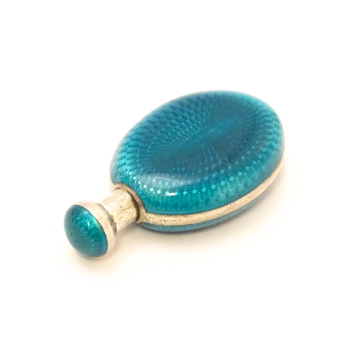 404 - A white metal scent / perfume bottle with turquoise guilloche enamel decoration. Indistinctly marked... 