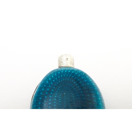 404 - A white metal scent / perfume bottle with turquoise guilloche enamel decoration. Indistinctly marked... 