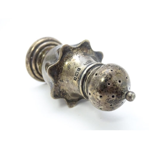 431 - A silver pepper of shaped form hallmarked Birmingham 1903, maker Turnbull Bros. Together with a silv... 