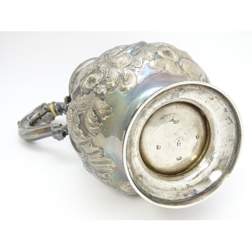 443 - Withdrawn from auction - A large Geo III silver hot water jug with embossed scrolling floral and fol... 