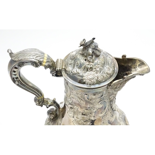 443 - Withdrawn from auction - A large Geo III silver hot water jug with embossed scrolling floral and fol... 