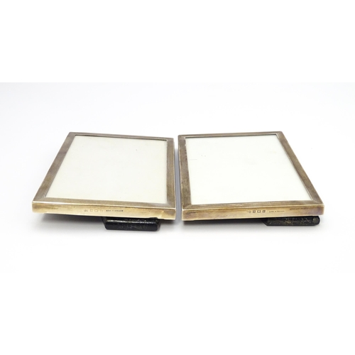 664A - A matched pair of easel back photograph frames with engine turned decoration with silver surrounds, ... 