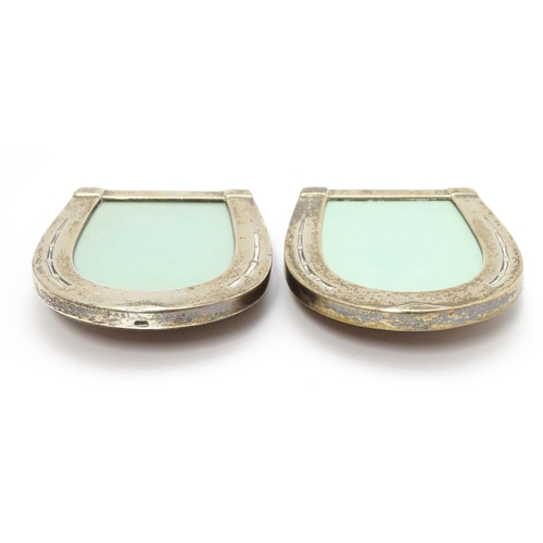 666 - A pair of easel back photograph frames with sterling silver surrounds of horseshoe form. Approx. 4 1... 