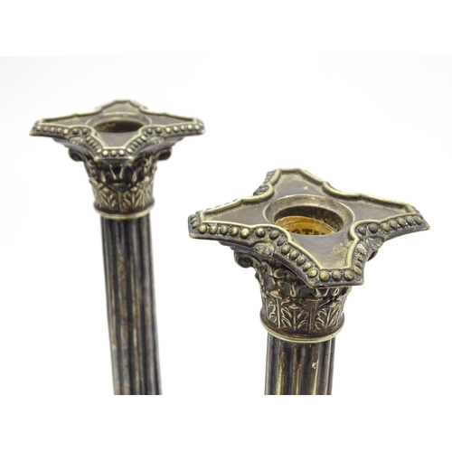 676 - A pair of silver plate candlesticks of column form with swag decoration. Approx. 12