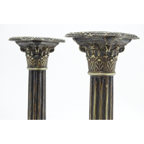 676 - A pair of silver plate candlesticks of column form with swag decoration. Approx. 12