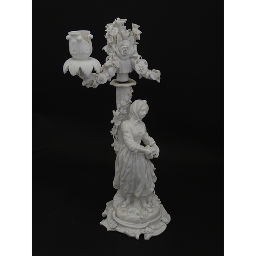 76 - A Continental figural candelabra depicting a woman on a naturalistic base with a tree. Bears Meissen... 