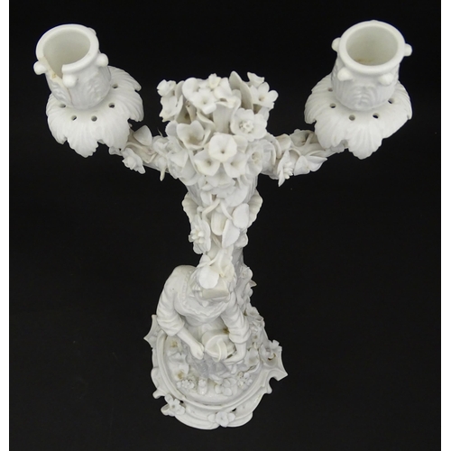 76 - A Continental figural candelabra depicting a woman on a naturalistic base with a tree. Bears Meissen... 