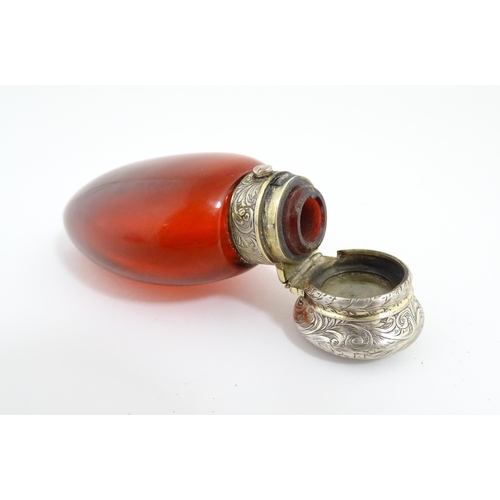 208 - A 19thC cranberry glass scent bottle / perfume flask with white metal top, maker GB. Approx. 3 1/2