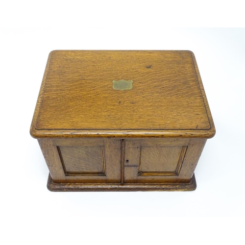 689 - An oak cased cutlery chest / canteen, the twin doors opening to reveal four fitted drawers within, c... 