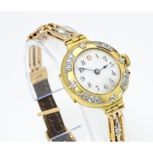 933A - An 18ct gold cased ladies wristwatch set with 12 diamonds, with white enamel dial, and 15ct gold bra... 