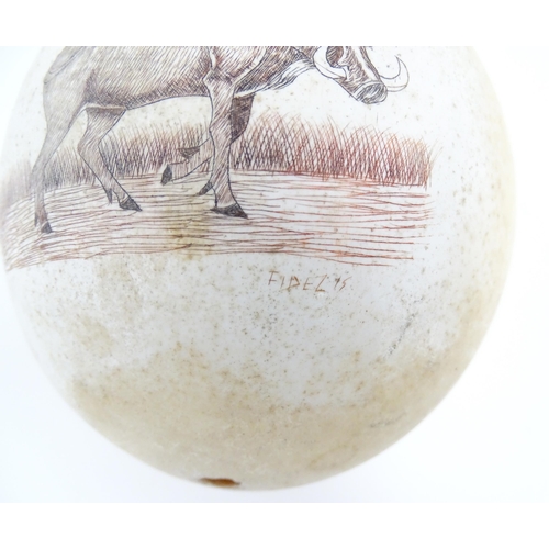 1145 - An ostrich egg with engraved decoration depicting a wild boar. Signed Fidelis lower right. Approx. 5... 