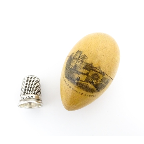 1149 - A 19thC Mauchline ware sewing thimble case of egg form with vignette depicting Carisbrooke Castle, c... 