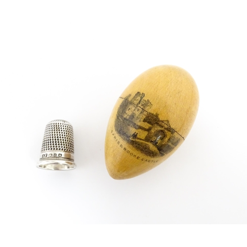 1149 - A 19thC Mauchline ware sewing thimble case of egg form with vignette depicting Carisbrooke Castle, c... 