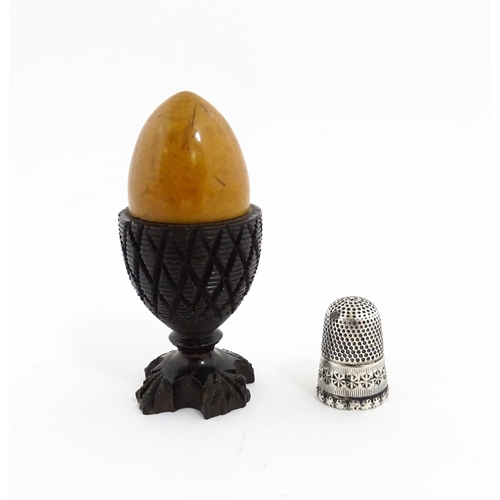 1152 - A 19thC treen / turned wooden thimble case and sewing thread holder of egg cup form, containing an e... 