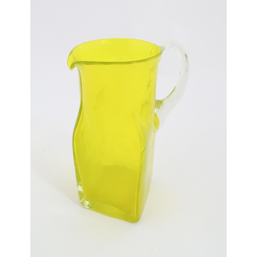 205A - A 20thC yellow glass jug with squared base and clear glass handle. Approx. 8 1/2