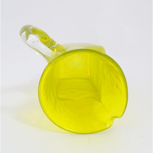 205A - A 20thC yellow glass jug with squared base and clear glass handle. Approx. 8 1/2