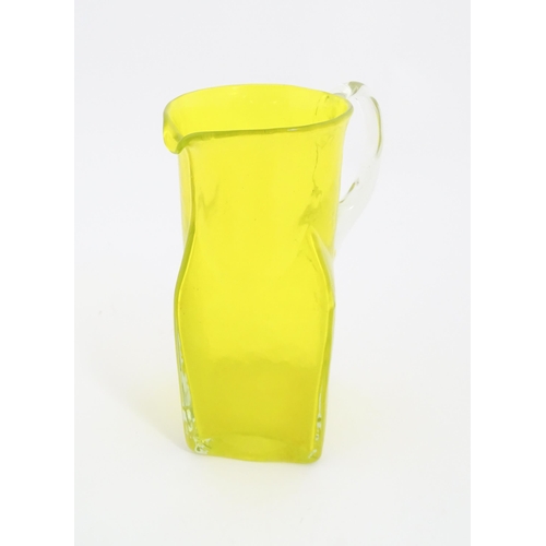 205A - A 20thC yellow glass jug with squared base and clear glass handle. Approx. 8 1/2