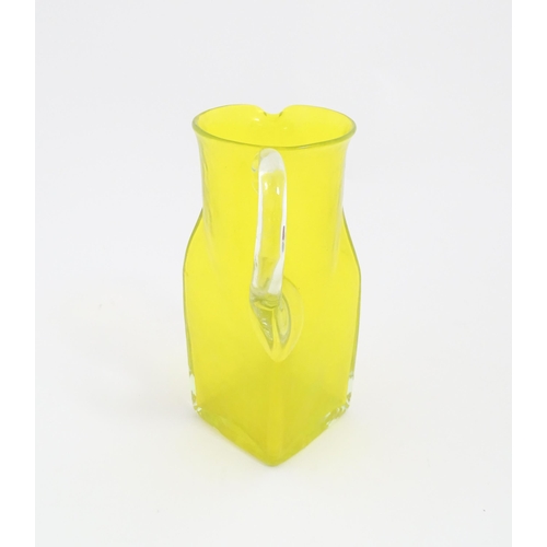 205A - A 20thC yellow glass jug with squared base and clear glass handle. Approx. 8 1/2