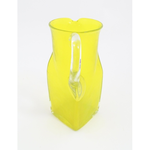 205A - A 20thC yellow glass jug with squared base and clear glass handle. Approx. 8 1/2