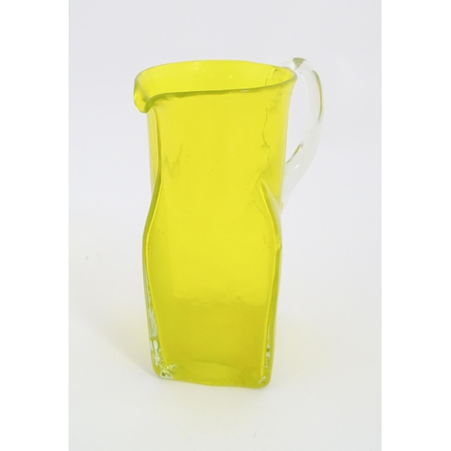 205A - A 20thC yellow glass jug with squared base and clear glass handle. Approx. 8 1/2