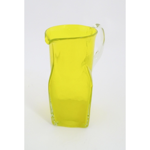 205A - A 20thC yellow glass jug with squared base and clear glass handle. Approx. 8 1/2