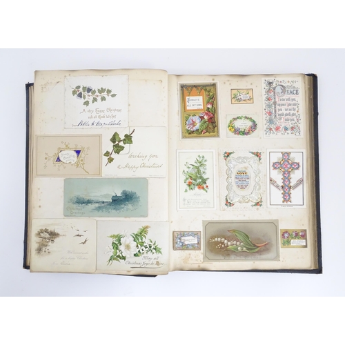 2140 - A late 19th / early 20thC scrapbook / greeting card album containing pressed flowers and foliage, va... 