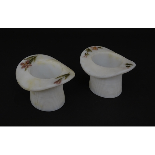 216 - A pair of milk glass match holders / vesta keeps  formed as top hats with hand painted floral detail... 