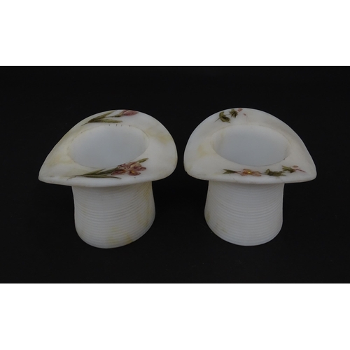 216 - A pair of milk glass match holders / vesta keeps  formed as top hats with hand painted floral detail... 