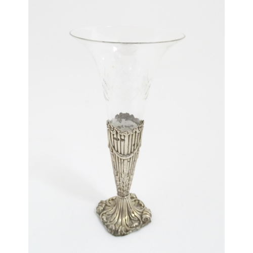 238 - A Victorian glass vase / epergne vase. The glass flute formed vase with silver base decorated with b... 