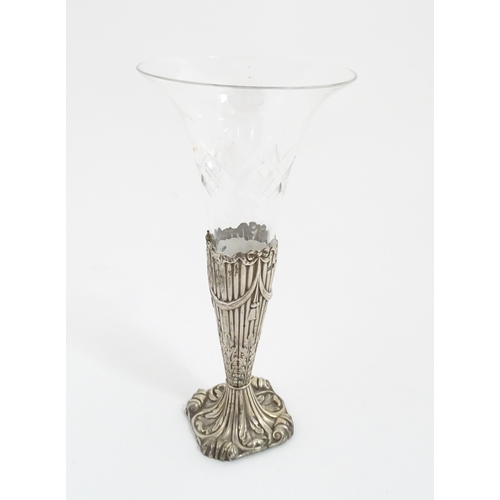 238 - A Victorian glass vase / epergne vase. The glass flute formed vase with silver base decorated with b... 