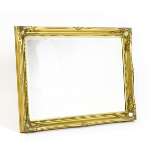 1673 - A modern gilt framed mirror with floral moulded corners and beaded decoration. 42