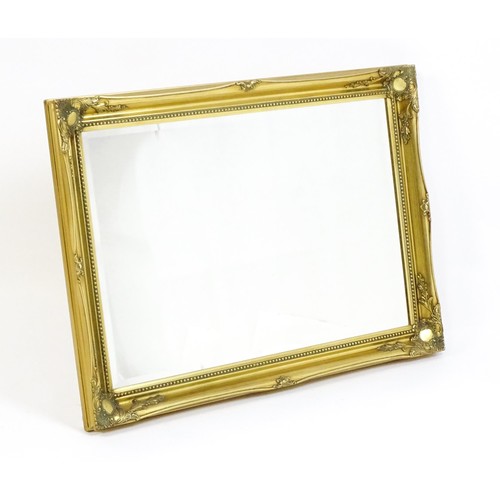 1673 - A modern gilt framed mirror with floral moulded corners and beaded decoration. 42