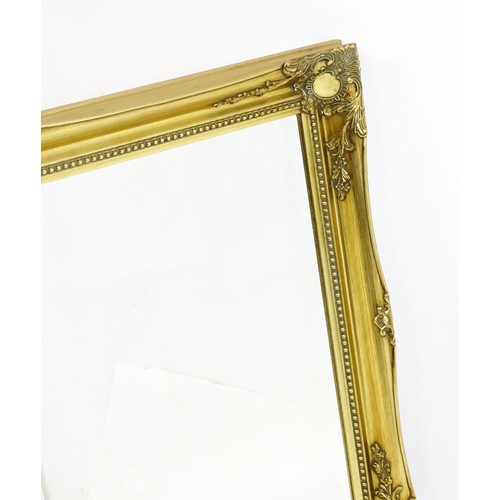 1673 - A modern gilt framed mirror with floral moulded corners and beaded decoration. 42