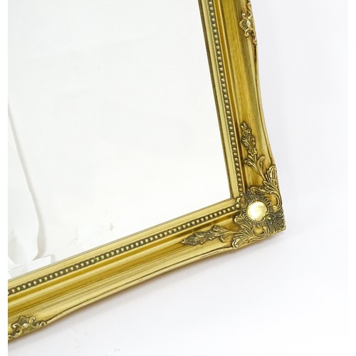 1673 - A modern gilt framed mirror with floral moulded corners and beaded decoration. 42