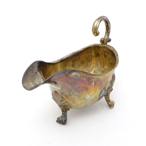 564 - A 19thC silver sauce boat raised on three feet, indistinctly marked. Approx. 7 1/2